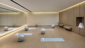 A modern, minimalist room with exercise balls, yoga mats, and a mirror. - Qingshan Lake Tianlan Hotel Hangzhou (Hangzhou)
