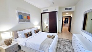 Una camera d'hotel moderna con un letto grande, comodini, uno specchio e un televisore.