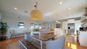 A spacious kitchen with a central island, white cabinetry, and a stainless steel refrigerator. - Coastal Escape w/ Pond Views + Pool Access | Graham’s Getaway by AvantStay (Port Aransas)