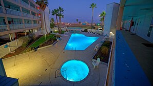 Ein Hotel mit Pool, Palmen und Blick auf den Strand.