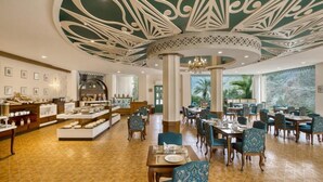 A hotel lobby with a central atrium, dining area, and a display of amenities. - Raga on the Ganges (Rishikesh)
