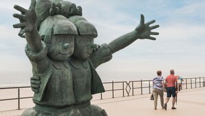 A statue of a child with arms raised, overlooking a beach. - Studio in Belgium with Sea View & Balcony (MIDDELKERKE)