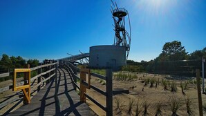 A wooden boardwalk leading to a cylindrical structure with a spiral staircase. - Studio in Belgium with Sea View & Balcony (MIDDELKERKE)