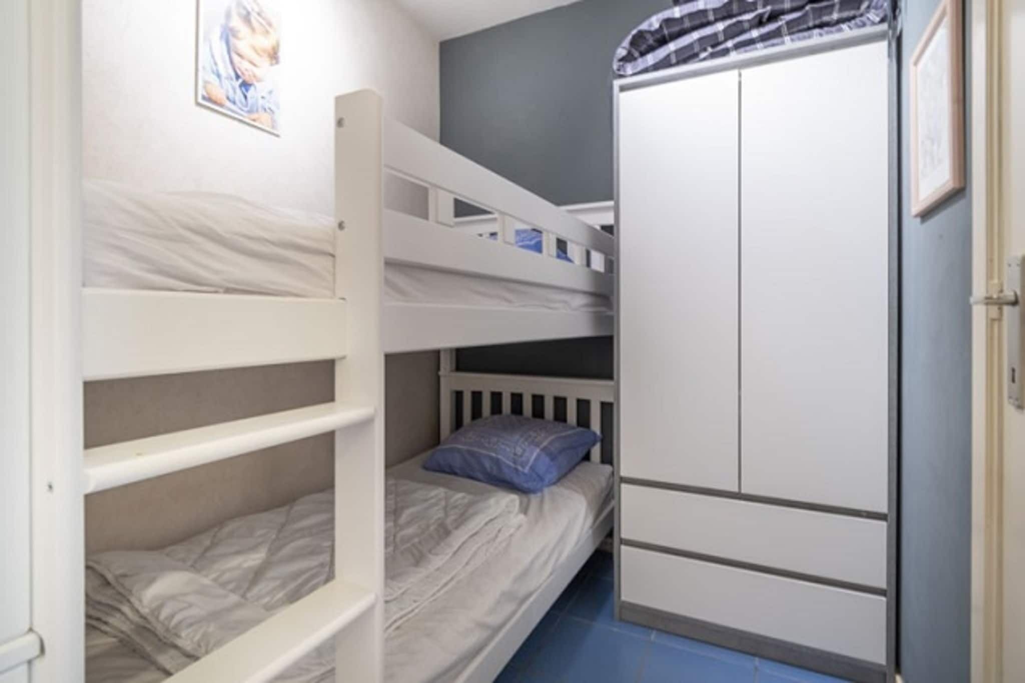 Habitació amb literes, un armari i un quadre al mur.