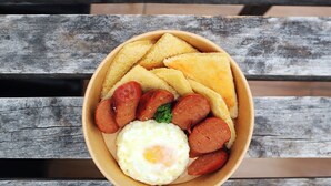 A bowl of food on a wooden table. - mySTAY BGC East (Makati)