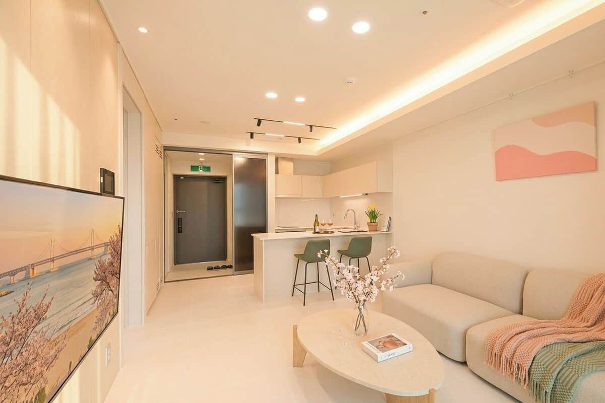 A modern hotel lobby with a reception desk, a sofa, a coffee table, and a painting on the wall.