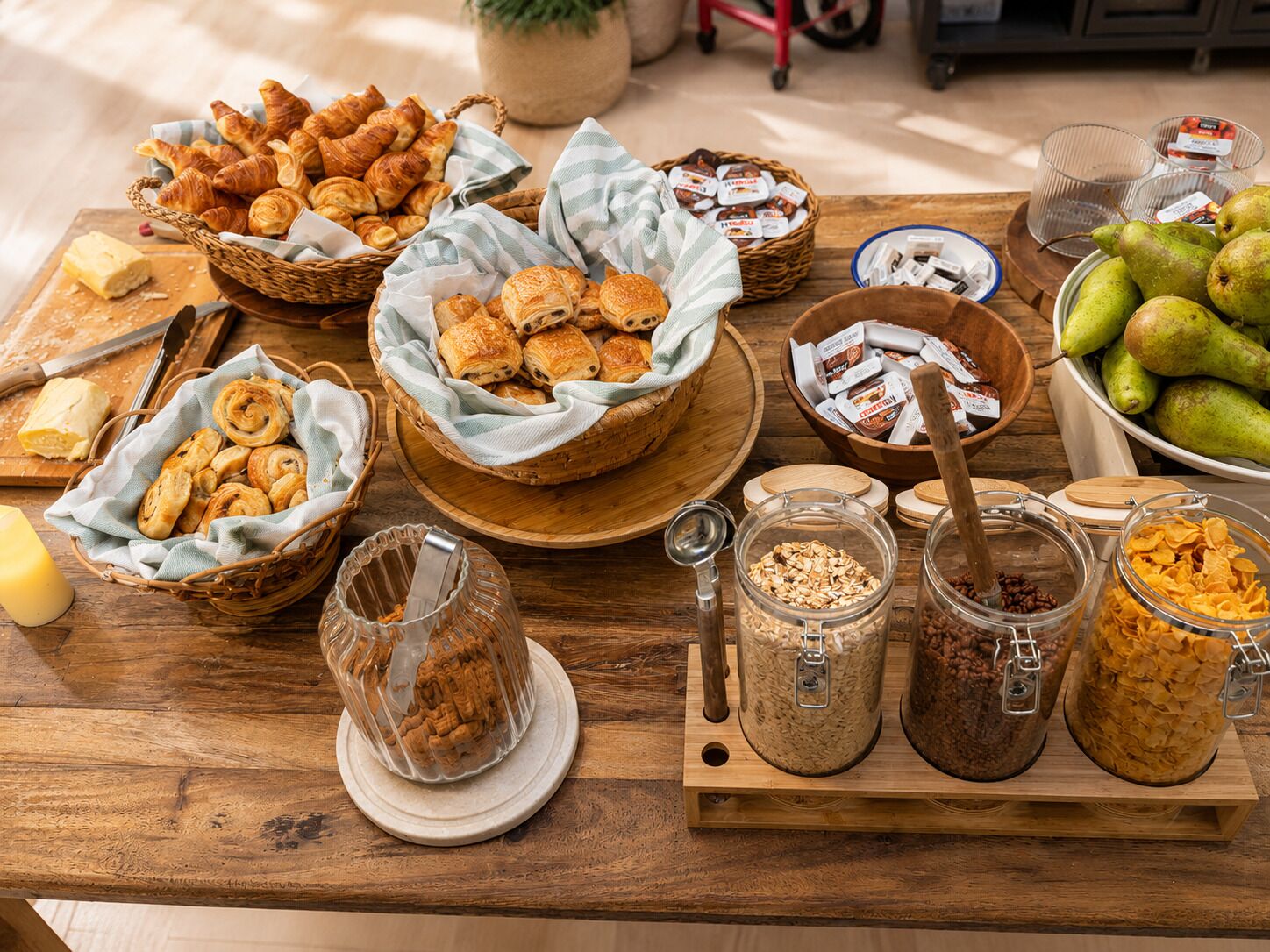 Una mesa de madera con diversas opciones de comida, como pasteles, frutas y botes con frutos secos y semillas.