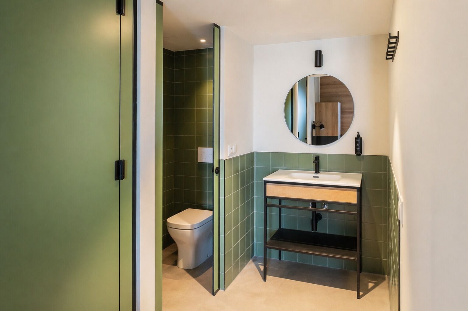 Un baño con inodoro, lavamanos y espejo.