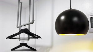 A modern pendant light with a spherical shade and a wall-mounted thermostat. - mySTAY BGC North (Makati)
