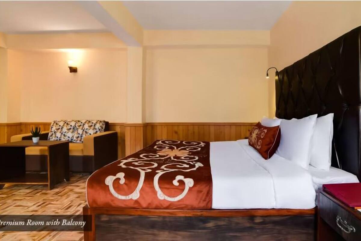 A hotel room with a bed, a desk, a chair, and a small table.