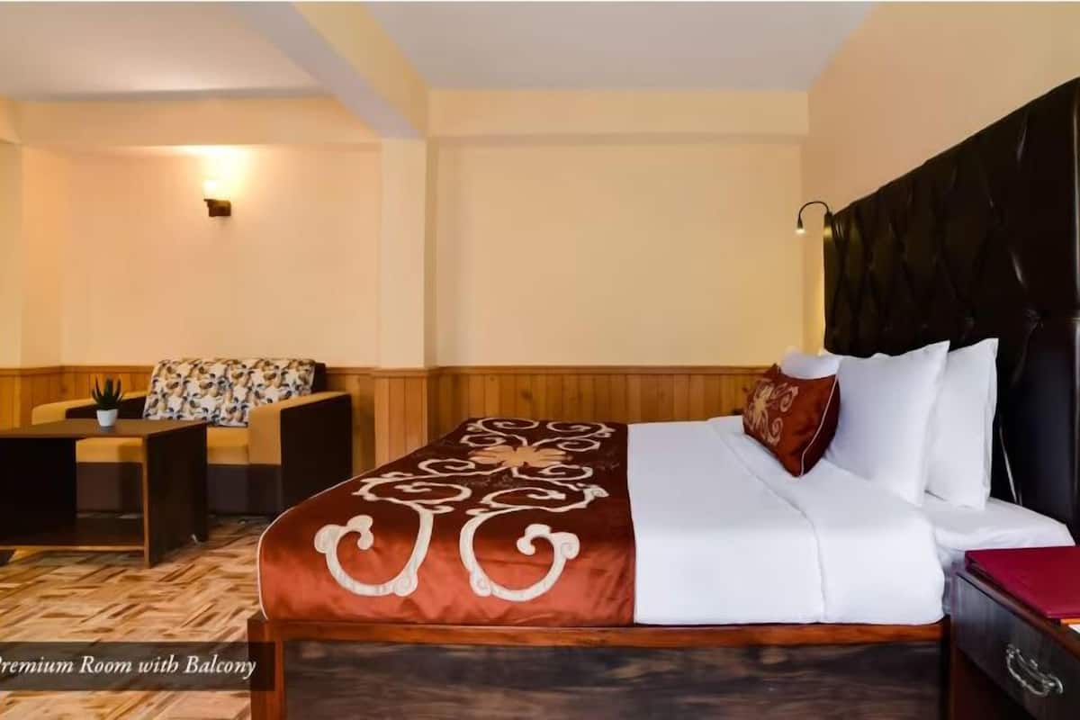 A hotel room with a bed, a desk, a chair, and a small table.
