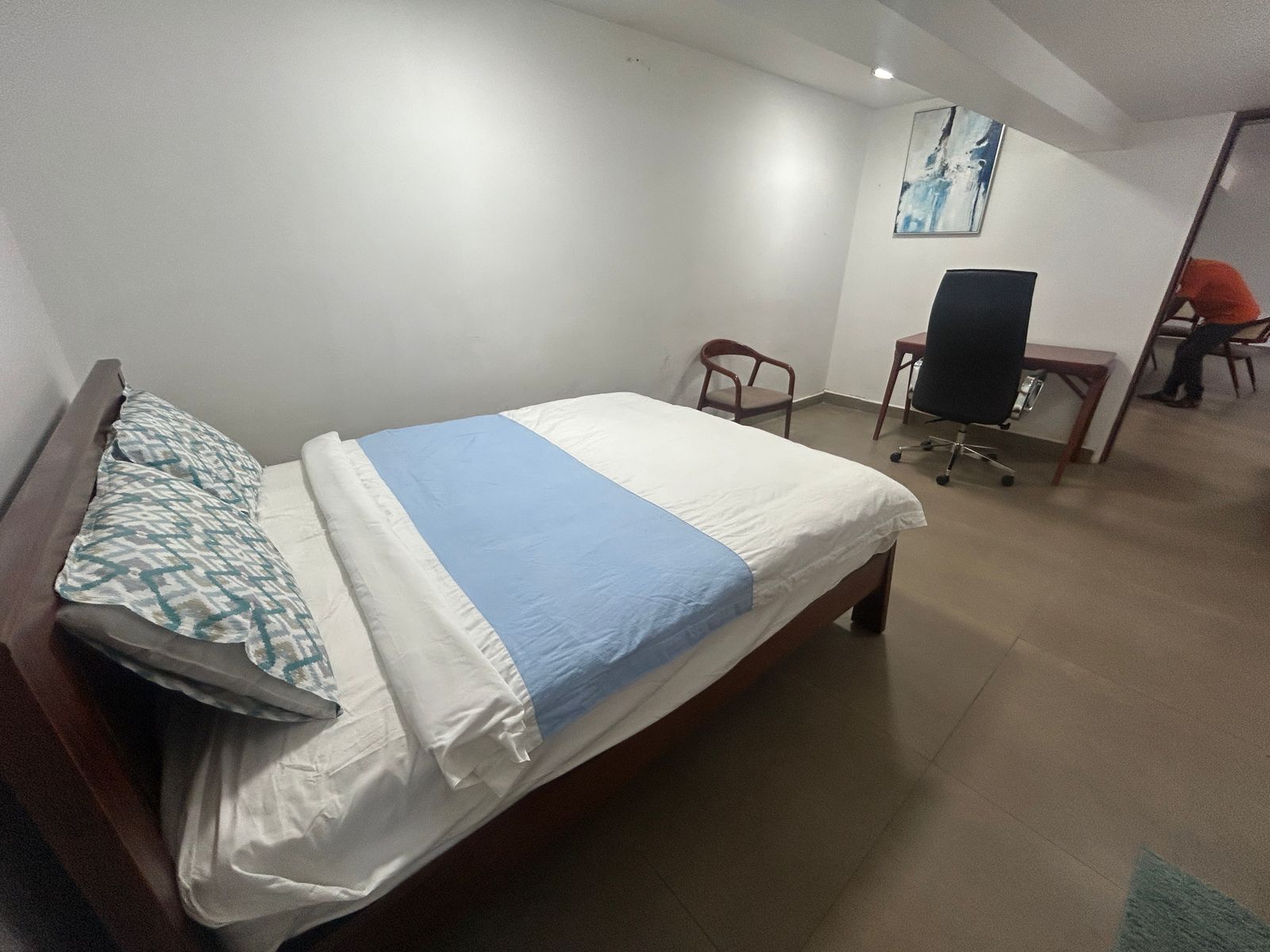 Una habitación de hotel con una cama, un escritorio y una silla.