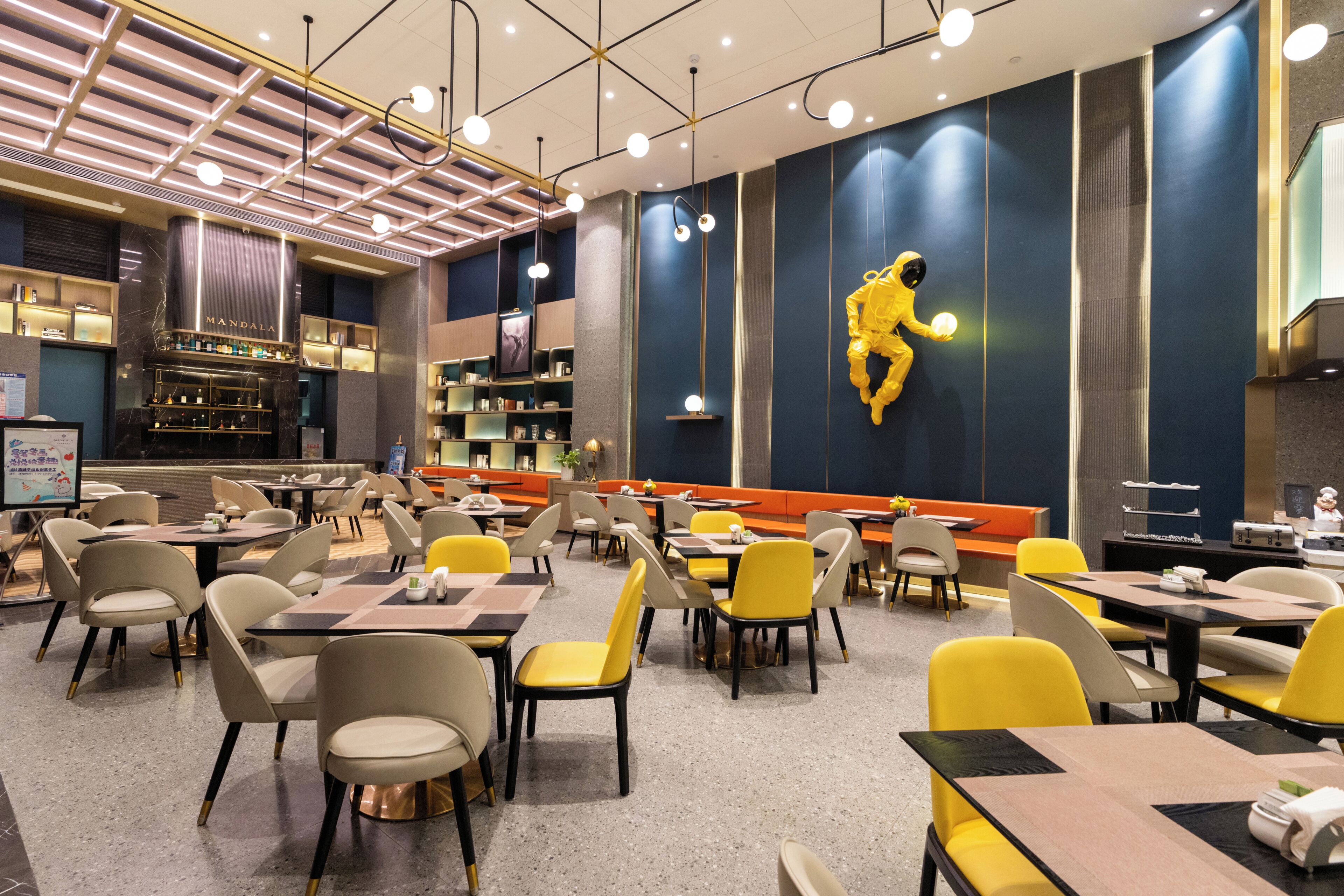 A modern restaurant with a variety of seating options, including tables and booths, and a bar area with shelves of bottles.