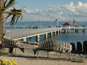A pier extending over water with benches and a small structure at the end.