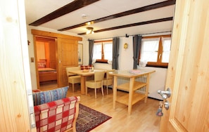 Una habitación acogedora con una mesa de madera, sillas, un banco y una puerta con una llave en la cerradura.