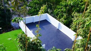 A rooftop pool surrounded by lush greenery and a view of a river and hills. - Palatty's Resort (Aluva)