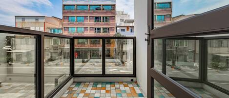A modern building with large glass windows and a colorful tiled floor.