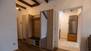 Ein modernes Interieur mit einem Holzschrank, einer Bank und einem eingebauten Kühlschrank.