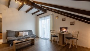 Ein gemütlicher Lofts-Wohnbereich mit Sofa, Couchtisch und einem Essbereich mit Stühlen.