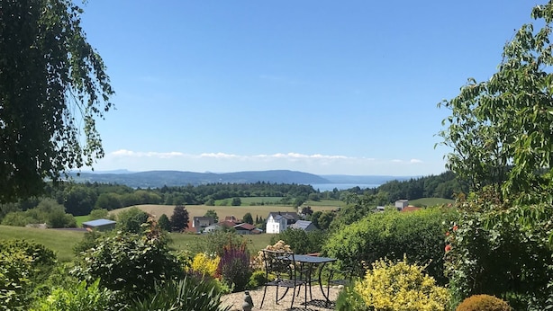 A rural landscape with a garden, a pond, and a view of distant hills. - Apartment 'Lotte Und Helmut Klanner' with Shared Terrace, Shared Garden and Wi-Fi (Daisendorf)