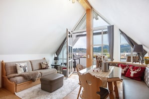 Une pièce de style loft comprenant un canapé, un pouf, une table à manger et des chaises.