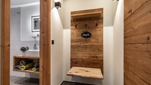Eine Holzwand mit einem hängenden Schild, einem Regal mit Handtüchern und einer Holzbank.
