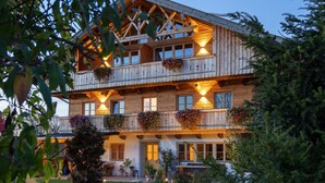 A two-story wooden building with balconies, windows, and a well-maintained garden. - Chalet 'Hochsitz' incl. Königscard (Gaißach)