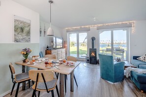 Une cuisine moderne avec un coin repas, une cheminée et une vue sur l’extérieur.
