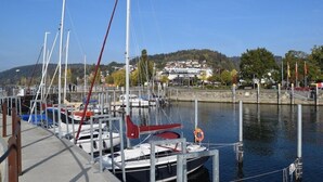 Een jachthaven met aangemeerde boten, een reddingsboei en een gebouw op de achtergrond.