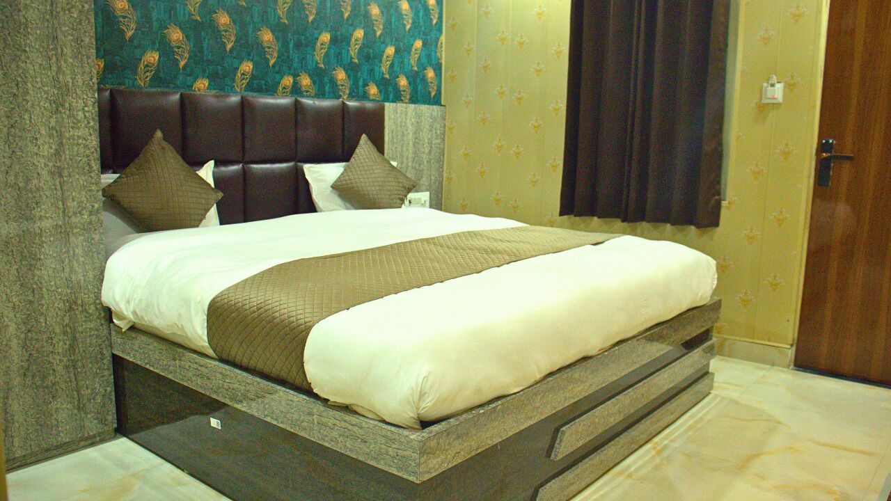 Una cama con cabecera, almohadas y una colcha.