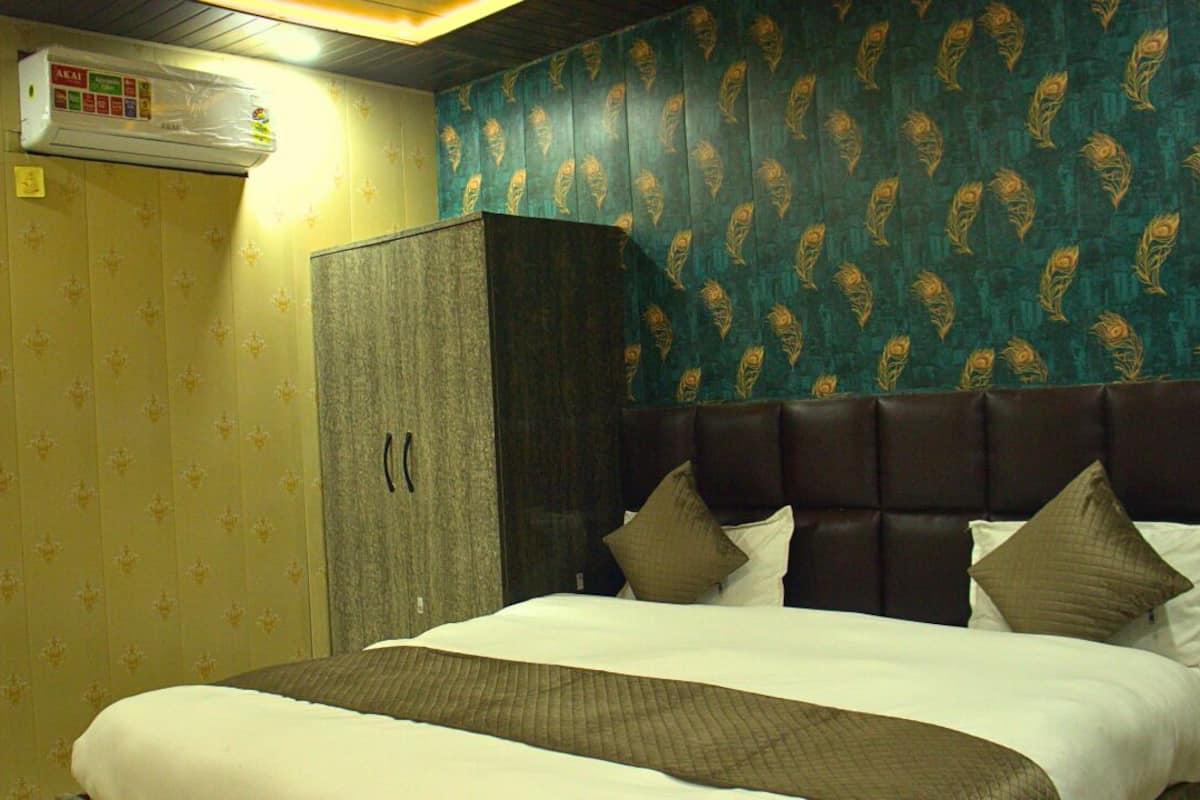 Quarto de hotel com cama, guarda-roupa e ar condicionado na parede.