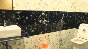 A bathroom with a white sink, a toilet, and a shower. - GANGA RIVERFRONT ROOMS AND BANQUET (Prayagraj)
