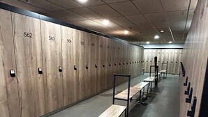 A locker room with numbered lockers, benches, and a tiled floor. - Apartment 2/4/6 pers. HYPER CENTRE, quiet (dead end) with PARKING, linen provided (Cauterets)