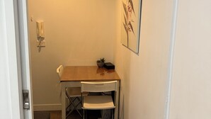 Een compact, netjes ingerichte kantoorruimte met een bureau, stoel en telefoon.