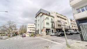 A street view with buildings, a cobblestone road, and parked cars. - Central Lodge Flat by House and People (Braga)