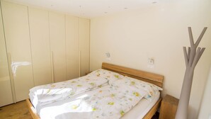 Ein Schlafzimmer mit einem hölzernen Bett, einem Kleiderschrank und einem Nachttisch.