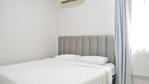 A neatly made bed with a grey headboard in a simple, clean room. - Sweety Secret Guesthouse (Bangkok)