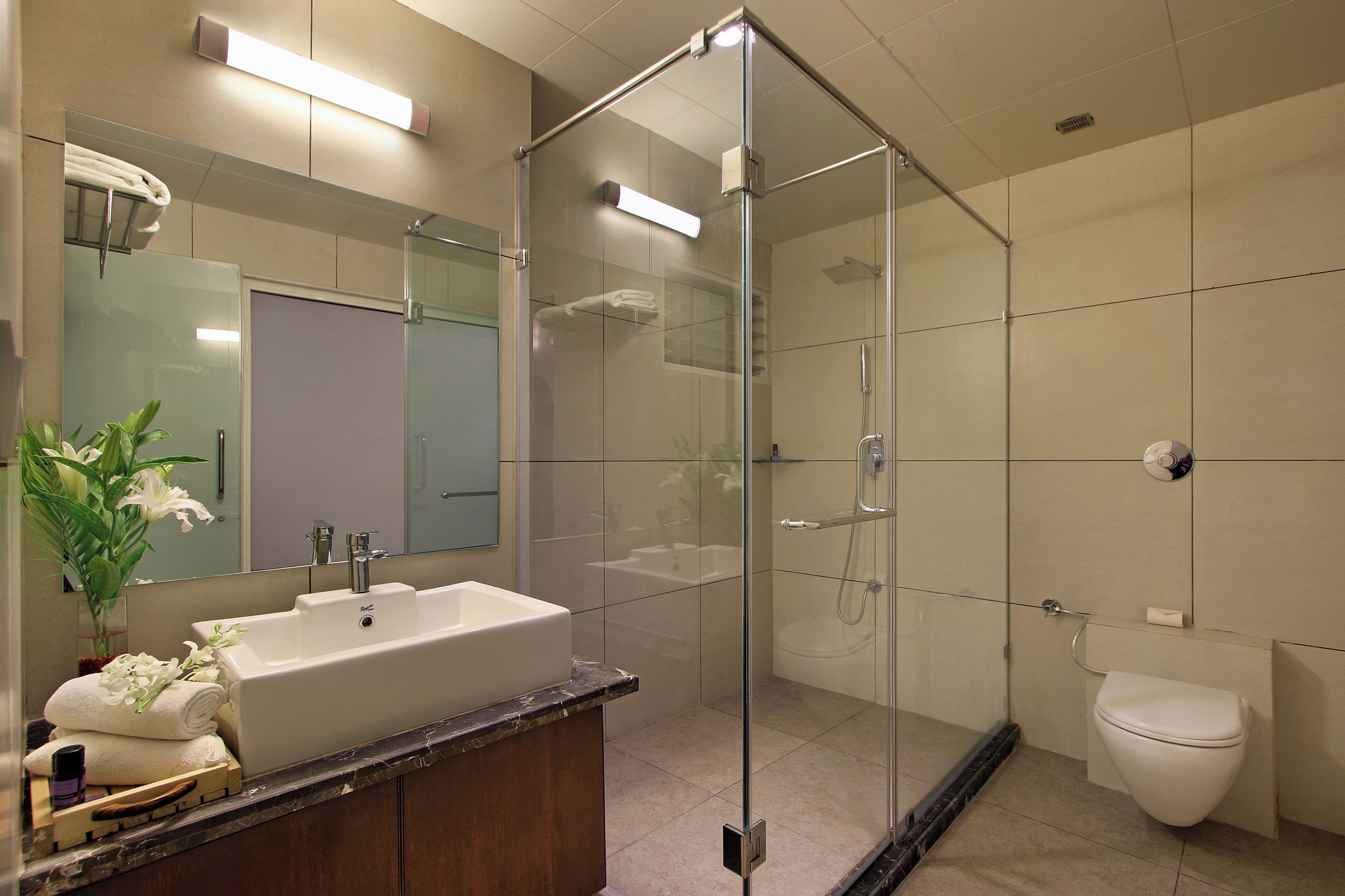 Ein modernes Badezimmer mit einer Duschkabine, einem Waschbecken mit Marmorplatte und einer Toilette.