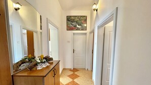 Un pasillo con un aparador de madera, un espejo y un cuadro en la pared.