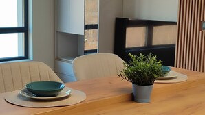 A modern kitchen with a wooden countertop, a potted plant, and a built-in TV.