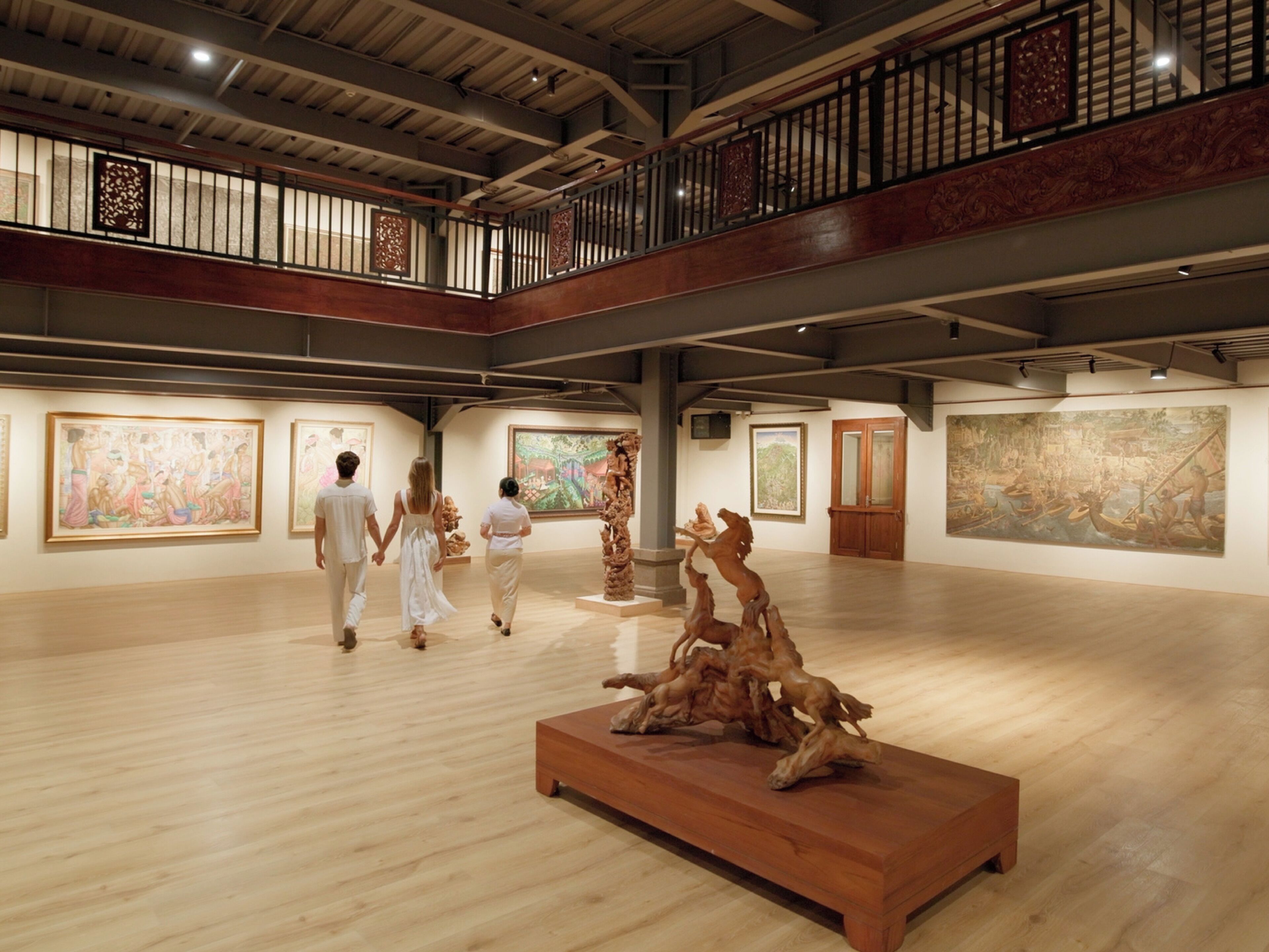 An art gallery with wooden floors and high ceilings.