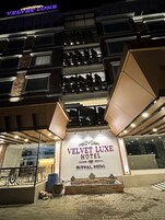 Exterior do Hotel Velvet Luxe, com entrada notável e várias varandas.