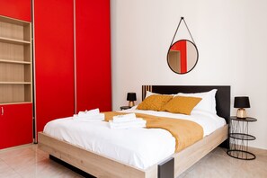 A modern bedroom with a wooden bed, red wardrobe, and a round mirror on the wall. - Maffi s House in Rome (Rome)
