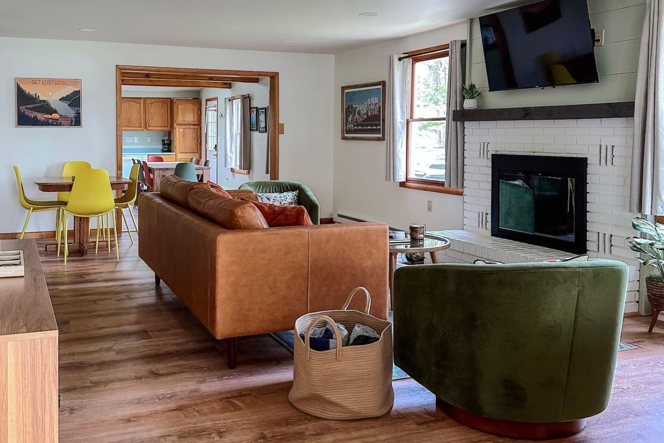 Un salon avec un canapé, un fauteuil vert, une table basse et une cheminée.