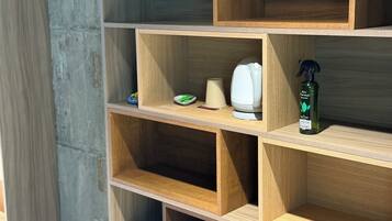 A wooden shelf unit with multiple compartments, some containing items like a white object, a green object, and a spray bottle labeled "Air Forest."