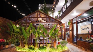 A covered outdoor seating area with plants and string lights. - Serena Tam Coc Hotel & Villa (Nam Hoa Lu)