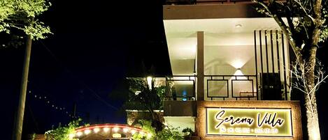 A two-story building with a neon sign reading "Serena Villa."