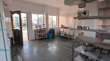Una cocina amplia con techos altos, ventanas grandes y electrodomésticos modernos.