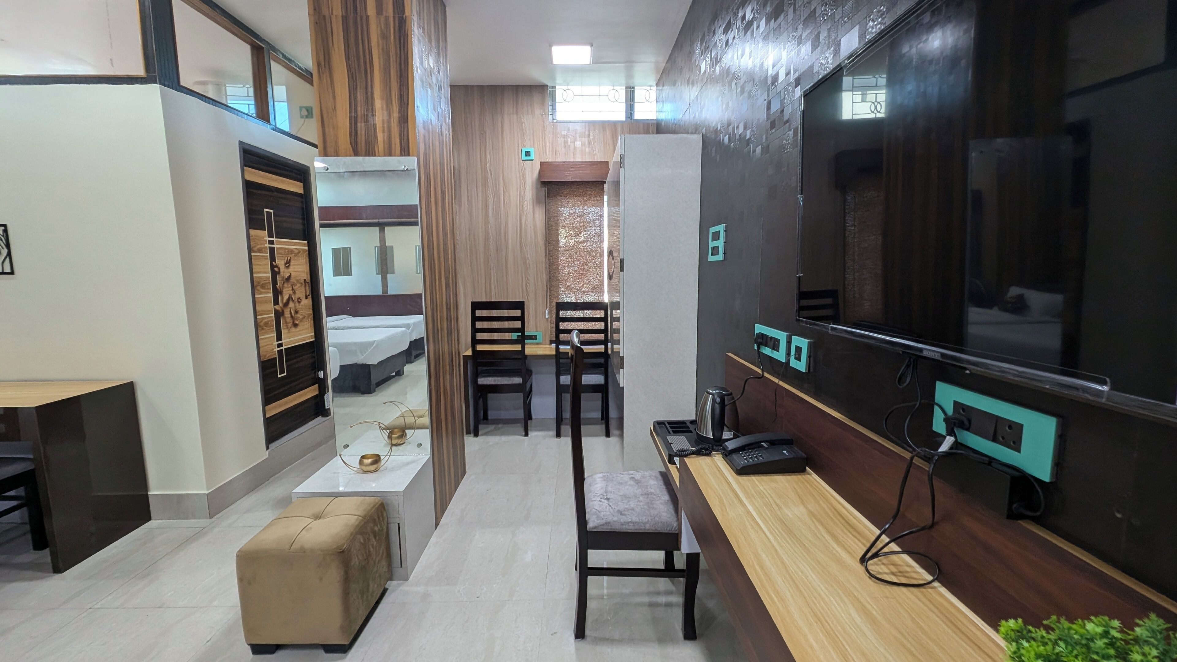 Una habitación de hotel moderna con una cama grande, un escritorio, una silla y un televisor.