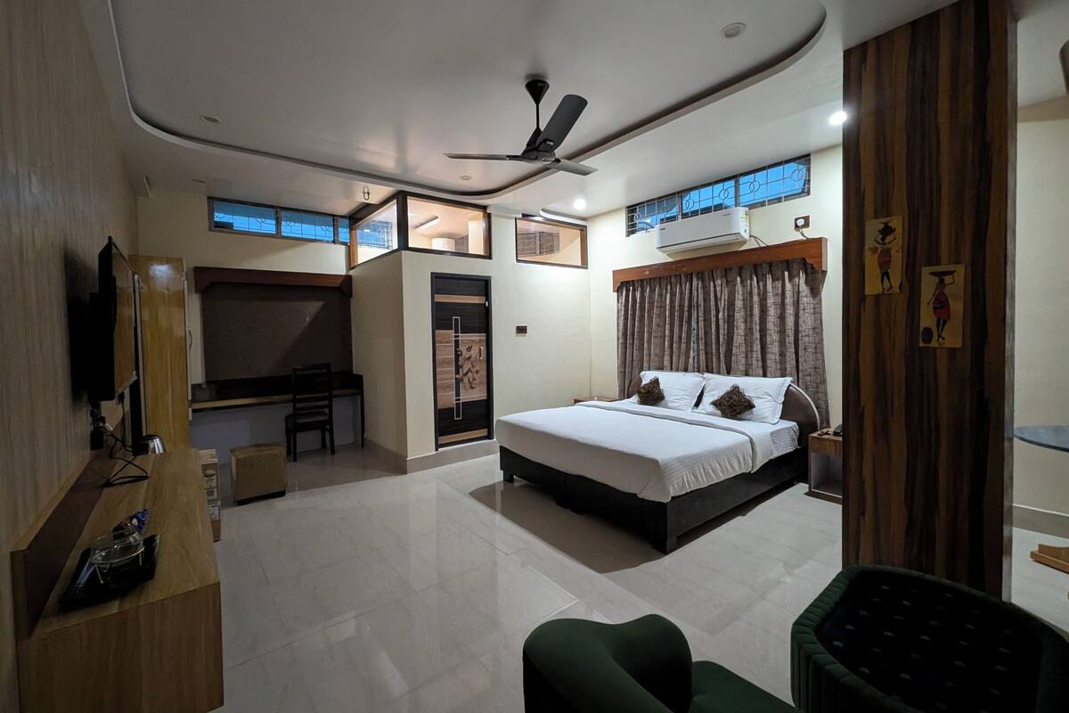 Een moderne hotelkamer met een bed, bureau en zithoek.
